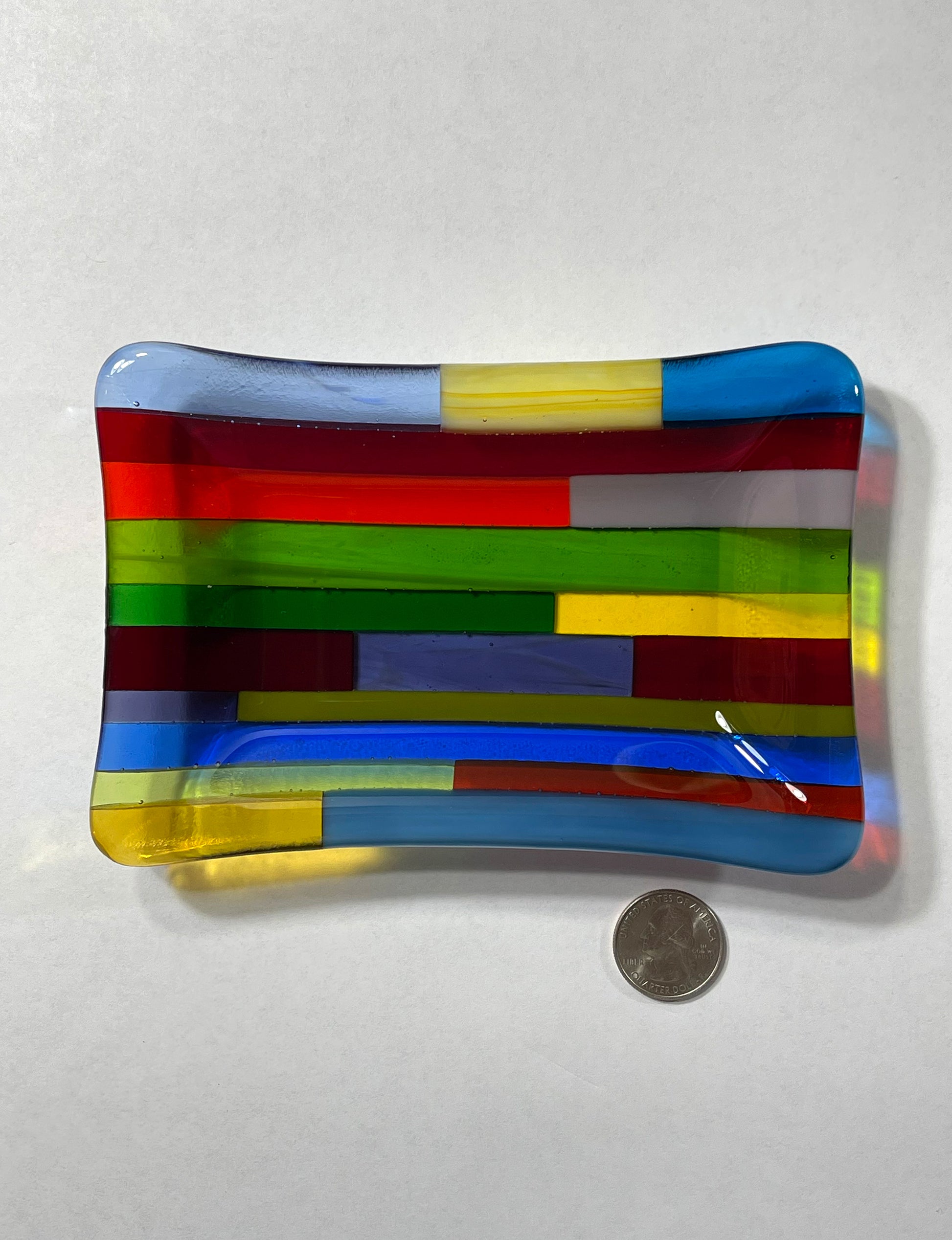 Blue dominant multicolor hard-edge fused glass dish by AWinburnART, detail view with quarter to show size
