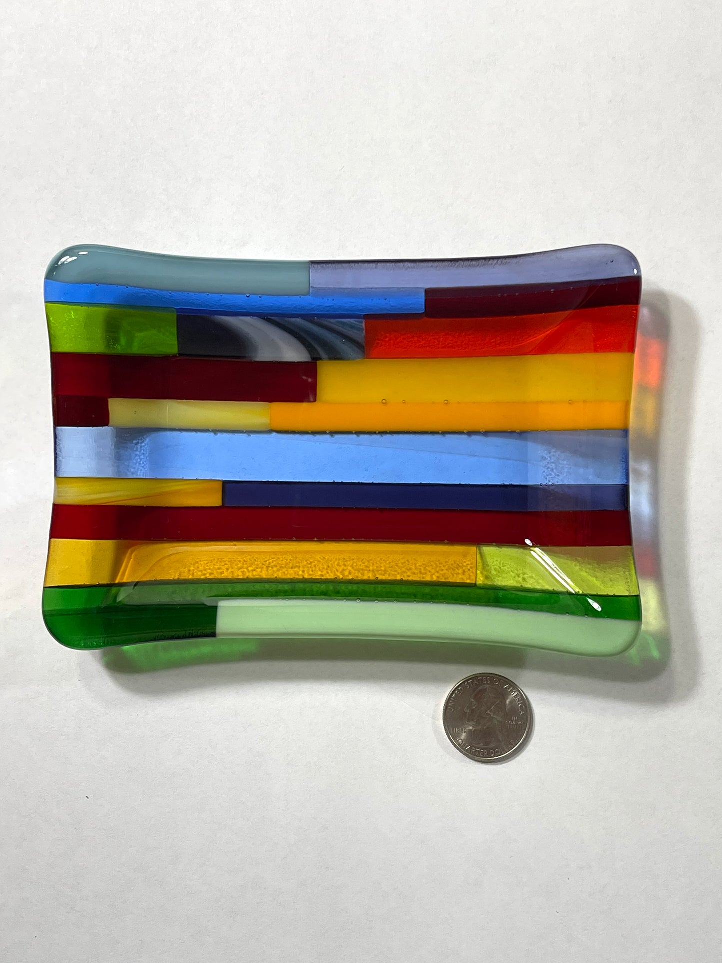 Yellow dominant multicolor hard-edge fused glass dish by AWinburnART with quarter to show size