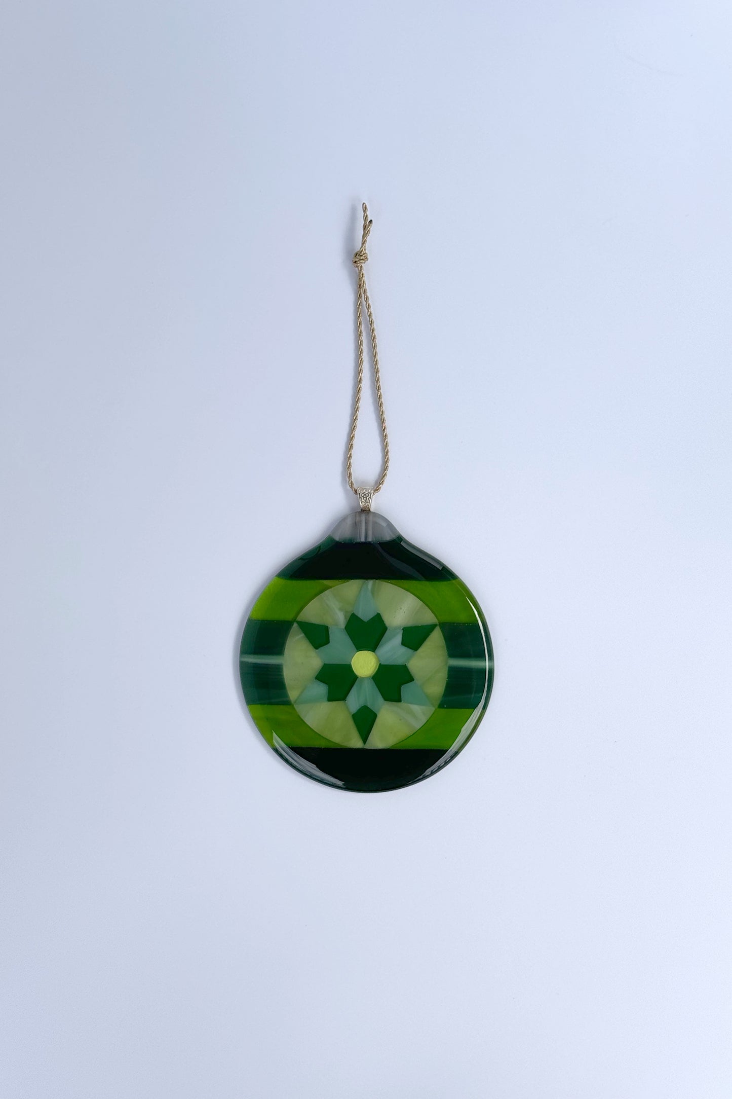 Handmade green fused glass 6-point star ornament against a white background by AWinburnART.