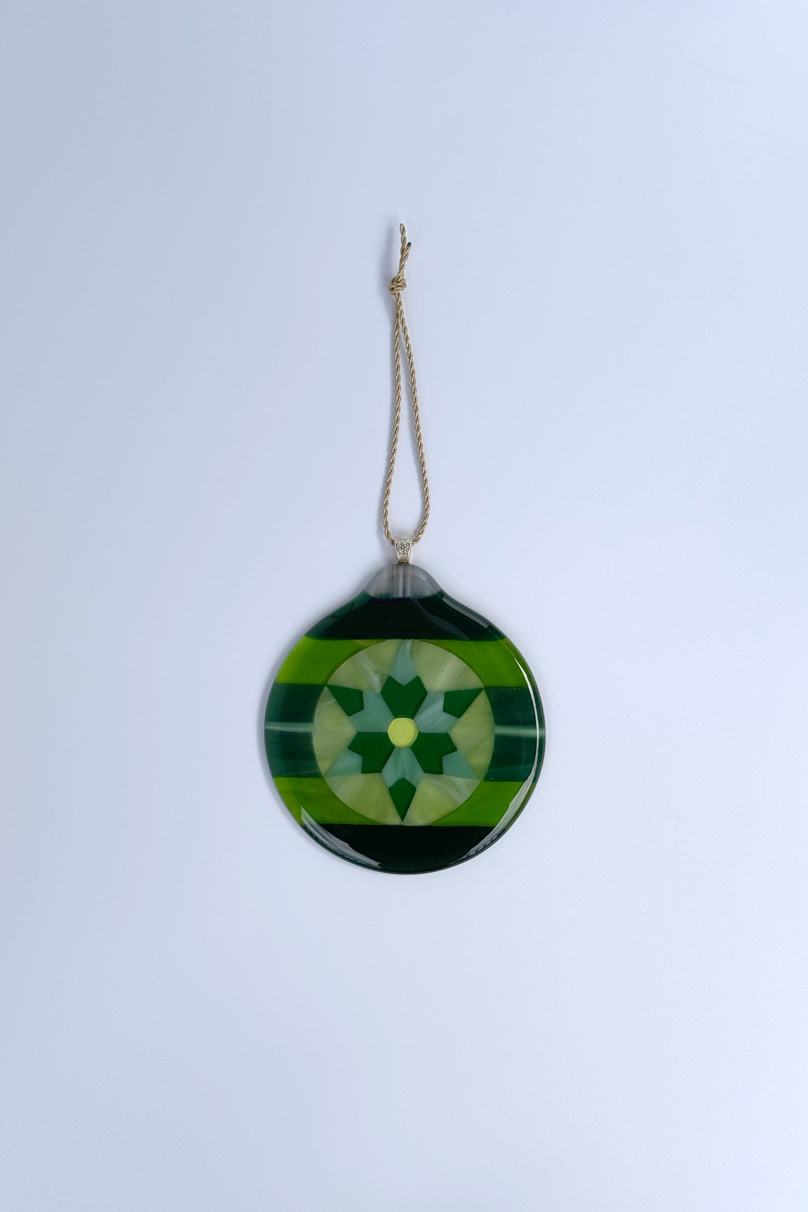 Handmade green fused glass 6-point star ornament against a white background by AWinburnART.