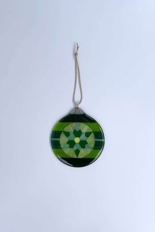 Handmade green fused glass 6-point star ornament against a white background by AWinburnART.