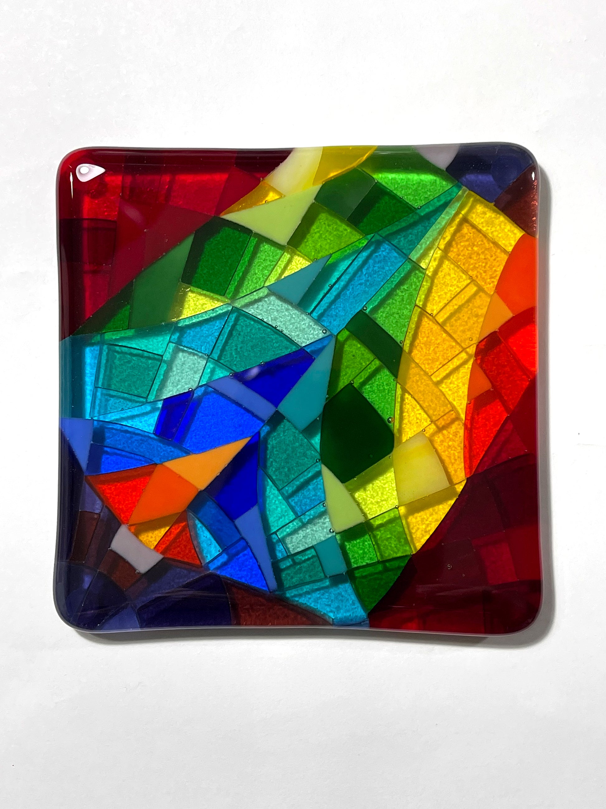 Lofty Dream, a one-of-a-kind multicolor hard-edge fused glass art coaster, full view, featuring a full-spectrum rainbow arc on a deep crimson base by Angie of AWinburnART.